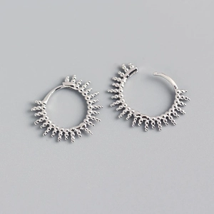 Macro view of silver hoop earrings featuring unique sunburst spike textured detailing