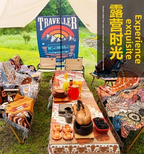 Detail of bohemian camping blanket with double-sided pattern and fringe tassels outdoors