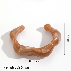 Detailed view of amber resin bangle showing dimensions 70mm by 84.5mm and 26.6g weight