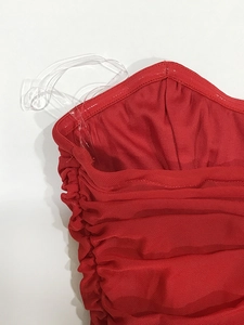 Detailaufnahme des roten Abendkleids mit gerafftem Netzstoff und Korsettstäbchen