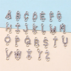 Detailed view of 26 alphabet charms with rhinestones and double rings for DIY jewelry