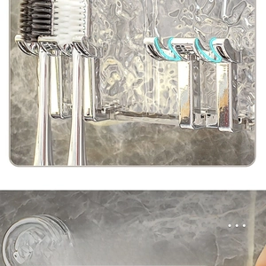 Close-up of wall-mounted toothbrush holder with silver U-hooks and vacuum suction