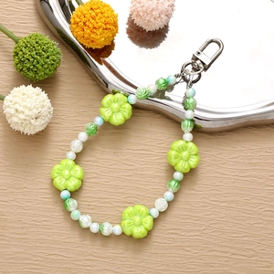 Detail of green acrylic flower beads and faux pearls with a silver metal clasp