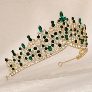 Detail of vintage gold crown with emerald green gems and sparkling crystals for weddings