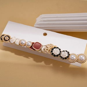 Détail de pince à cheveux vintage avec perles, fleurs et accents d'étoiles dorées