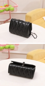 Detailed view of the side profile and top flap on a black quilted leather chain bag
