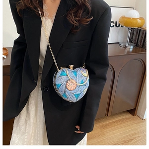 Detail of heart-shaped evening bag with blue and orange sequins and gold chain strap