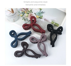 Close-up of matte bow hair claws in five colors including burgundy and navy blue