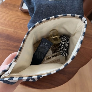 Macro detail of striped canvas makeup bag with metal zipper and spacious interior