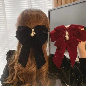 Detail of velvet bow hair clips in black and wine red with pearls and sequins for girls