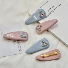 Détail de barrettes à cheveux nouées roses et bleues avec ornements logo Saturne