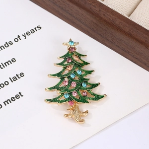 Detailed view of green enamel Christmas tree brooch with pink and blue rhinestones