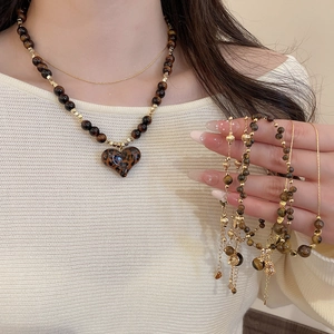 Detailed view of vintage tiger eye necklace with heart leopard print pendant and beads