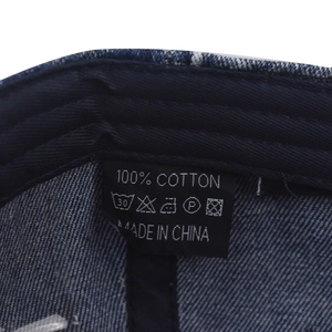 Detail view of denim baseball cap interior showing 100% cotton sweatband and care label