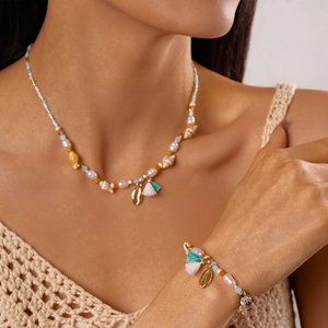 Bohemian jewelry set featuring colorful beads, pearls, and shell pendants on a model