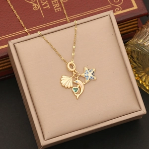 Gold necklace with shell, dolphin and starfish pendants inside a beige jewelry box
