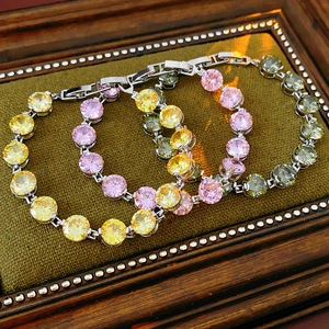 Detailed shot of vintage zircon bracelets in yellow pink and green on velvet