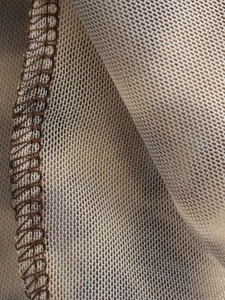 Macro view of beige mesh knit fabric texture and high-quality overlock stitching details