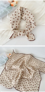 Detail view of cotton linen scarf with brown heart pattern and soft edge stitching