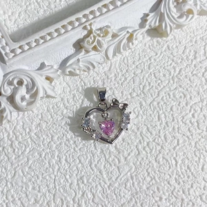 Detailed macro of a pink heart pendant with zircon butterfly and 18K gold plating
