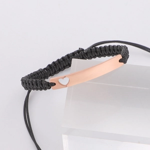 Adjustable black wax rope bracelet with a rose gold curved bar and hollow heart design