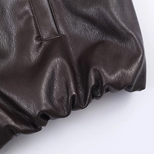 Detail of dark brown faux leather jacket with lychee texture and elastic cuff finish