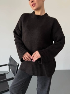 Detail of the oversized black knitted sweater showing loose fit and premium fabric texture