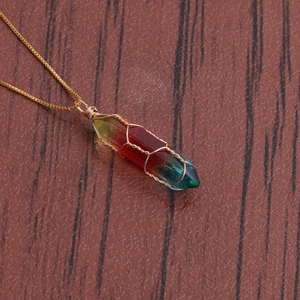 Top view of a gold wire wrapped hexagonal rainbow crystal column pendant on a fine chain