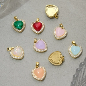 Colorful resin heart pendants with rhinestone borders and gold-plated frames in a flat lay view