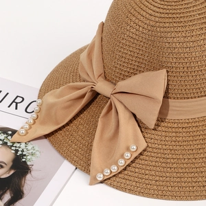 Khaki straw sun hat with elegant silk bow and pearl accents in a stylish side view