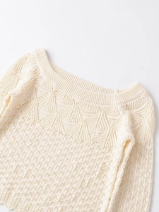 Detailed close-up of knit hollow-out texture on collar and shoulder of off-white sweater