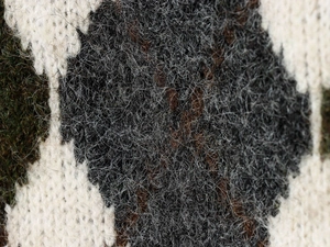 Macro shot of fluffy mohair texture and black-white geometric diamond knit pattern
