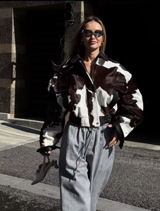 Close-up of stylish black and white cow print jacket with soft faux fur texture detail