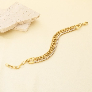 Macro detail of triple-layered gold bracelet featuring Cuban links and zircon accents