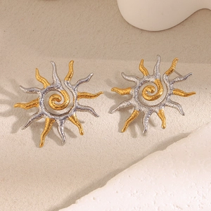 Detailed shot of two-tone sun-shaped earrings in gold and silver textured metal