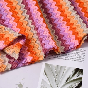 Detailed close-up of zigzag wave pattern knit fabric in vibrant warm color tones