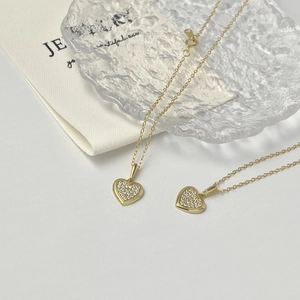 Close-up of heart-shaped 18K gold plated S925 silver necklaces with sparkling cubic zirconia