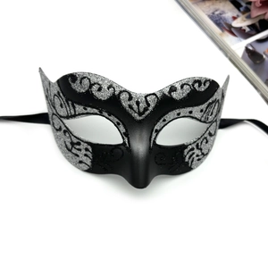 Detailed view of lace-style masquerade mask featuring silver glitter scroll patterns