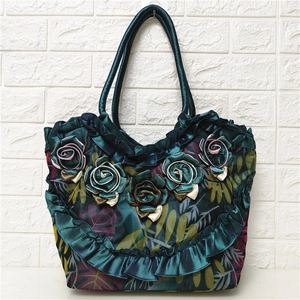 Detail of dark green satin shoulder bag with 3D ribbon flowers and ruffles
