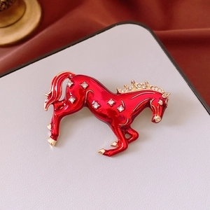 Macro shot of running horse brooch with red enamel and sparkling zircon inlay