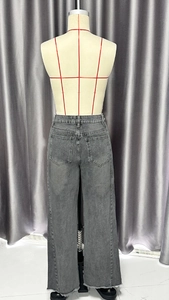 Détail de la poche arrière et de l'ourlet brut d'un jean large gris foncé à taille haute