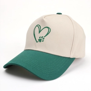 Détail de la casquette bicolore avec visière verte et logo cœur sur toile de coton