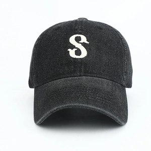 Close-up of white letter S embroidery on high-quality black washed denim baseball cap