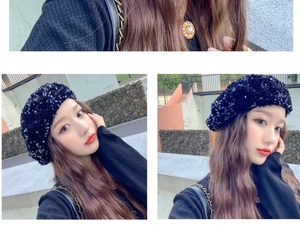 Detail shot of a black sequin beret showing sparkling texture and outdoor model look