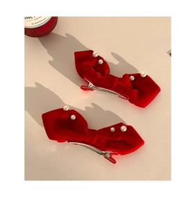 Detail of red velvet bow hair clips with white pearl accents and metal backing