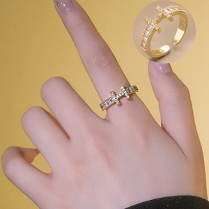 Anello regolabile placcato oro a forma di H con zirconi su sfondo caldo