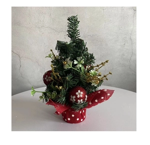 Close-up of mini Christmas pine tree with red berries and polka dot fabric base decoration