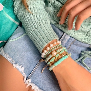 Close-up of bohemian multi-layered bracelet set with freshwater pearls and turquoise beads