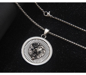 Detail of a silver lion head pendant on box chain with sleek stainless steel finish