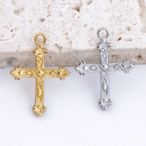 Detailed view of gold and silver cross pendants with ornate baroque patterns on stone texture